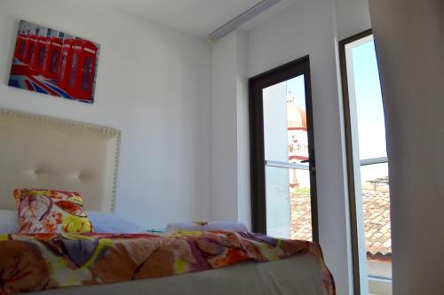 a white room with a bed and a window at Hotel San Fernandos Plaza in San Rafael
