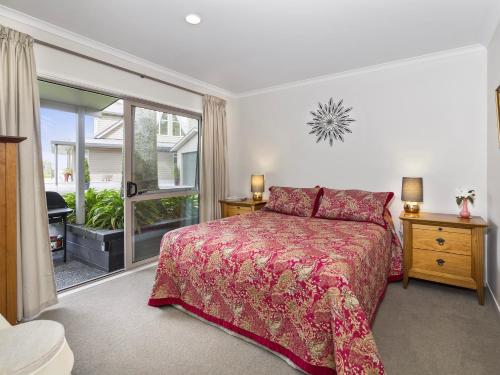 a bedroom with a bed and a large window at Te Miro Cottage - Lake Tarawera Cottage in Lake Tarawera