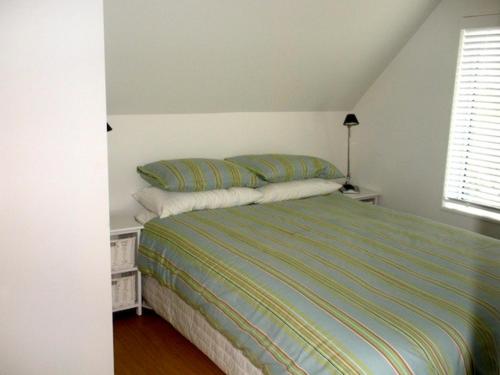 a bedroom with a bed with two pillows on it at Tiromoana - Mathesons Bay Holiday Home in Leigh