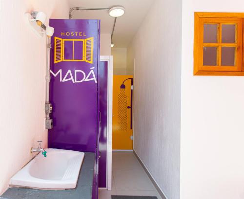 a bathroom with a purple door and a sink at MADÁ hostel in Sao Paulo