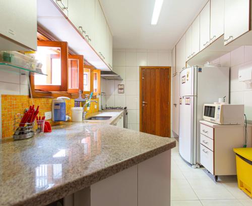 a kitchen with white appliances and a counter top at MADÁ hostel in Sao Paulo