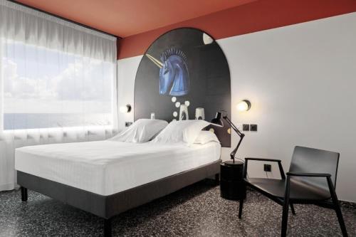 a bedroom with a large bed and a chair at DINA MORGABINE SAINT DENIS in Saint-Denis