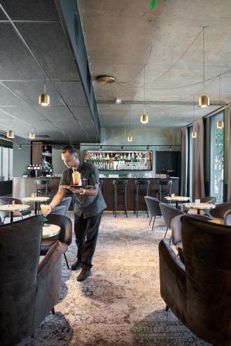 a man standing in a restaurant with a plate of food at DINA MORGABINE SAINT DENIS in Saint-Denis