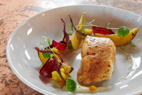 a plate of food with fish and vegetables on a table at DINA MORGABINE SAINT DENIS in Saint-Denis