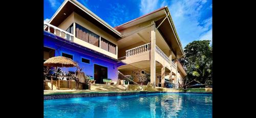 a large house with a swimming pool in front of it at Hotel Beachfront Vista Hermosa in Jacó