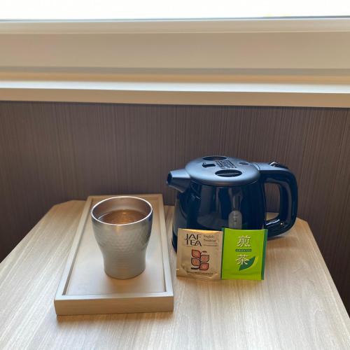a tea pot and a cup on a table at Route Inn Grantia Tokai Spa&Relaxation in Tokai