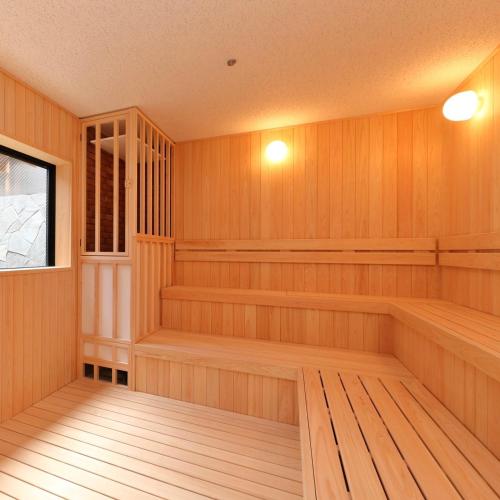 a sauna with wood paneling and a window at Route Inn Grantia Tokai Spa&Relaxation in Tokai