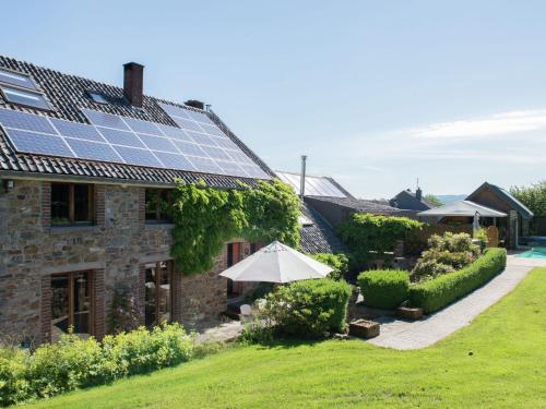 uma casa com painéis solares no telhado em Ruim vakantiehuis in Theux met een zwembad em Desnié