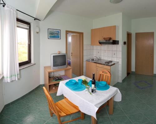 a living room with a table and chairs and a kitchen at Apartments Cetina in Split