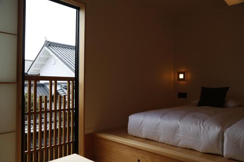 a bedroom with a bed and a large window at yubune in Onomichi