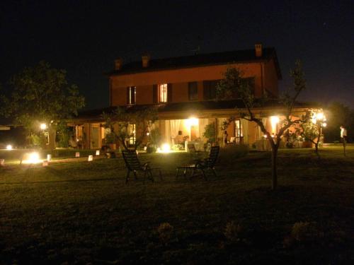 a house at night with chairs in front of it at La Fornasaccia in Cesena
