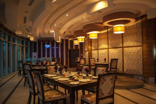 a dining room with a long table and chairs at Jacaranda Heights in Islamabad