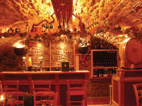 a bar in a wine cellar with red chairs at Hotel Drei Könige in Neckarbischofsheim