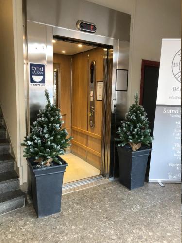 two potted trees sitting in front of a door at Strand City Hotel in Örnsköldsvik