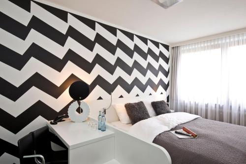 a bedroom with a black and white chevron wall at Hotel & Restaurant Rosenthal Casino in Selb