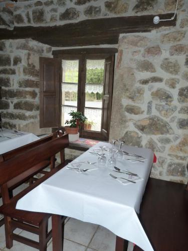 a dining room with a white table and a window at Hotel Rural Los Texos in La Riera