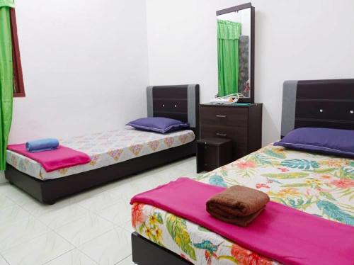 a room with three beds and a mirror at Depulauserai Budget Home No AirCond in Pekan