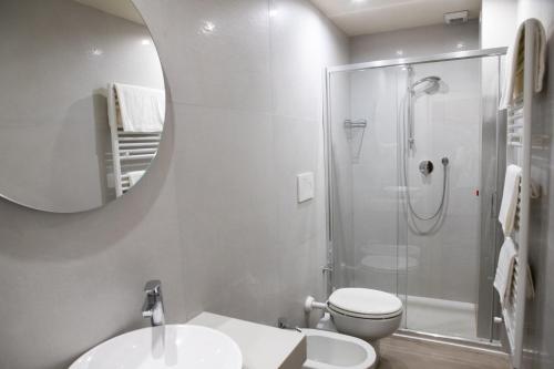 a bathroom with a shower and a toilet and a mirror at Hotel Nuovo Savi in Montecatini Terme
