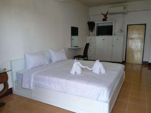 ein Schlafzimmer mit einem weißen Bett und Handtüchern darauf in der Unterkunft OYO 560 Chang Hostel Suvarnabhumi in Bangkok