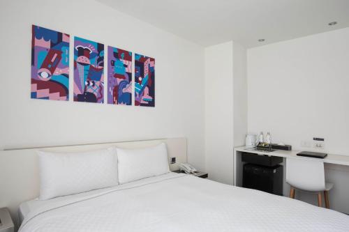 a bedroom with a white bed and a desk at CityInn Hotel Taipei Station Branch II in Taipei