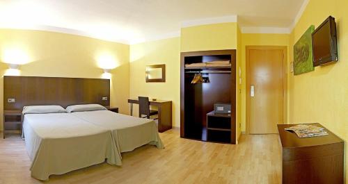 a hotel room with a bed and a desk at Hotel Florencio Ibiza in San Antonio