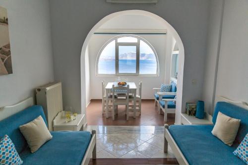 a living room with an archway and a table and chairs at Acrothea Suites and Villas - Akrotiri Caldera - Santorini in Akrotiri