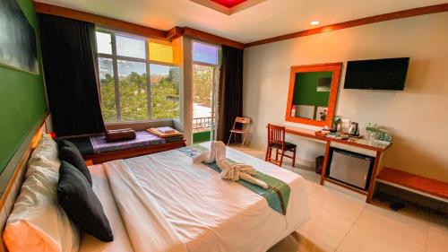 a bedroom with a bed and a desk and a mirror at K2 Hotel at Thachang in Ban Pa Yang