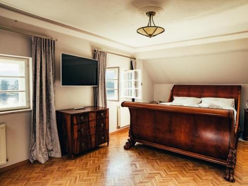 a bedroom with a bed and a flat screen tv at Hotel Schloss Dürnstein in Dürnstein