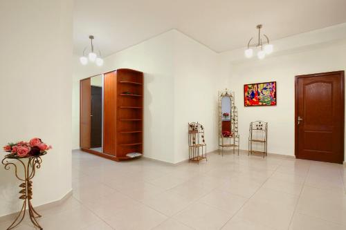 Großes Zimmer mit weißen Wänden und einem braunen Schrank in der Unterkunft 3 Bedroom Apartment in Homey Residence in Yerevan