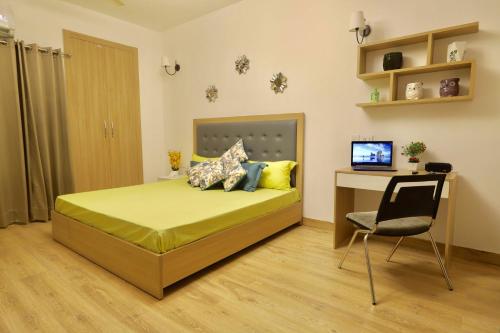 a bedroom with a bed with a desk and a chair at The Karma Square near India Expo Mart in Noida