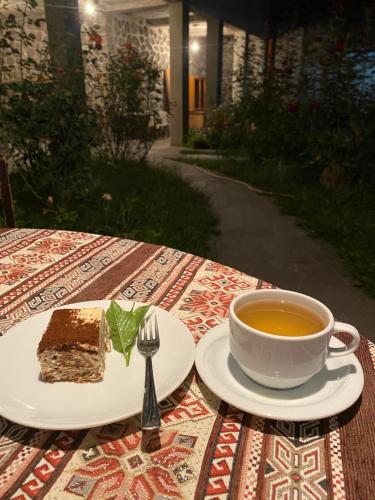a piece of cake and a cup of tea on a table at Christy Hotel in Goris