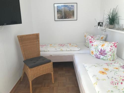 um quarto com uma cama, uma cadeira e um sofá em Oland Whg 17 Wellenflüstern em Wyk auf Föhr