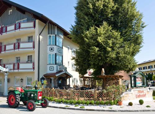 a green tractor parked in front of a building at Ortner's Resort in Bad Füssing