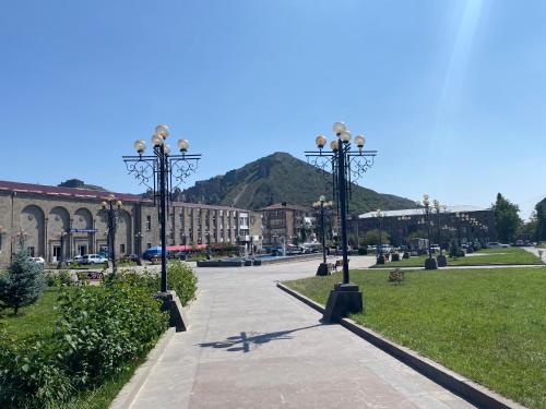 a park with street lights and a mountain in the background at Christy Hotel in Goris