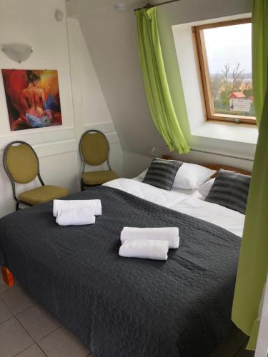 two beds in a room with two chairs and a window at Avila Park & SPA in Dziwnówek