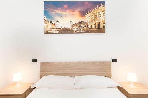 ein Schlafzimmer mit einem Bett und zwei Lampen in der Unterkunft Piazza Bengasi Cozy Apartment in Turin