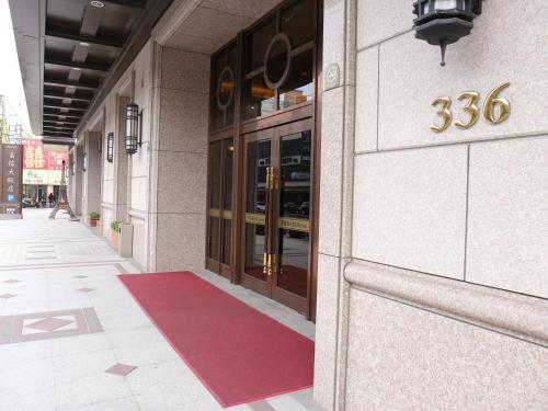 un bâtiment avec un tapis rouge devant une porte dans l'établissement Fushin Hotel - Tainan, à Tainan