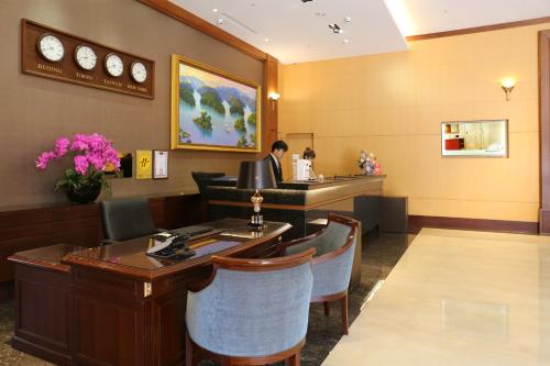 a lobby of a hotel with a bar and a person sitting at a counter at Fushin Hotel - Tainan in Tainan