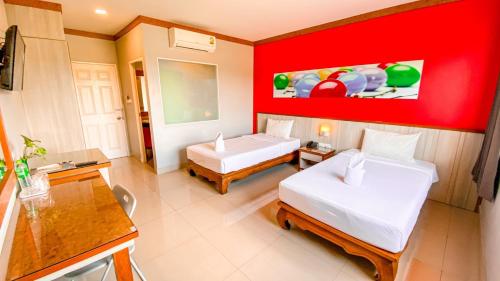 a room with two beds and a red wall at K2 Hotel @ Airport in Surat Thani