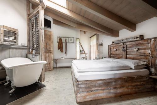 a bedroom with a large bed and a bath tub and a sink at Berry House in Vigolo Vattaro