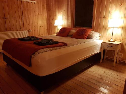 a bedroom with a large bed with two lamps on it at Guesthouse Didi in Flagbjarnarholt