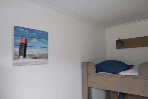 a bedroom with a bed and a painting on the wall at Sier aan Zee in Hollum