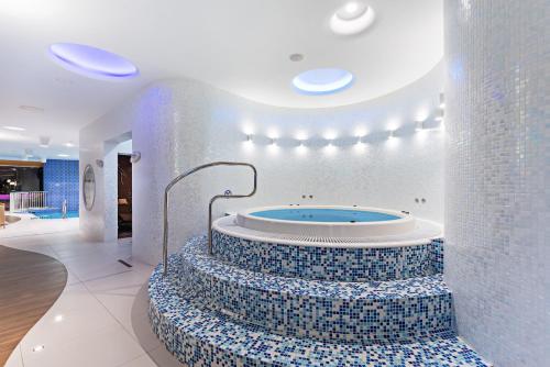 a bathroom with a tub with blue and white tiles at Kulibin Park Hotel & SPA in Nizhny Novgorod