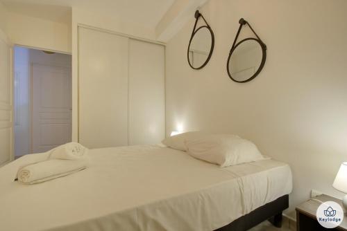 een witte slaapkamer met een bed met twee handdoeken erop bij T2 - Fiorella - Piscine et terrasse - 36m2 - Saint-Denis in Sainte-Clotilde