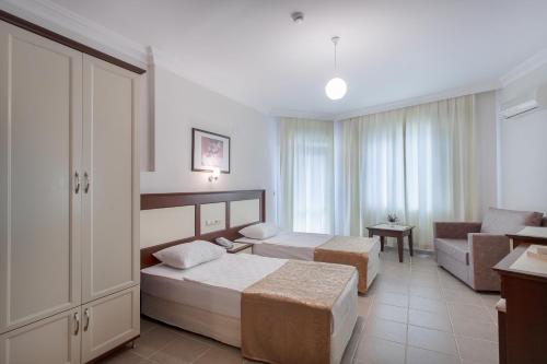 ein Hotelzimmer mit 2 Betten und einem Sofa in der Unterkunft Kaila City Hotel in Alanya