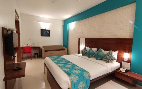 a bedroom with a large bed with a blue wall at The Temple View Hotel in Shirdi