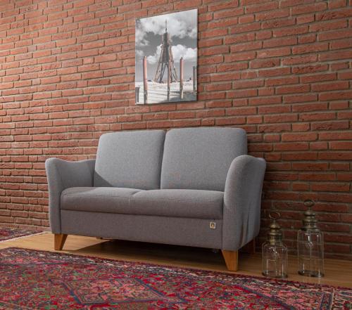 a couch sitting in a room next to a brick wall at Haus Wattenblick in Cuxhaven