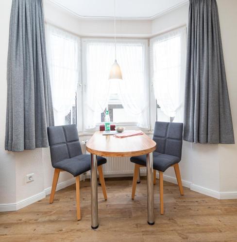 a dining room with a table and two chairs at Haus Wattenblick in Cuxhaven