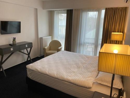 a hotel room with a bed and a desk and a television at Urban 7 Residence in Bucharest