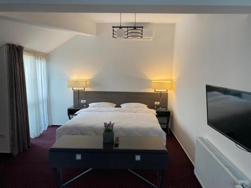 a hotel room with a bed and a tv at Urban 7 Residence in Bucharest